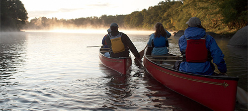 L.L.Bean Outdoor Discovery Schools. Canoe Maine Lakes and Ponds. A canoe tour embarks on an adventure as the morning mist rises off the water of a calm lake.
