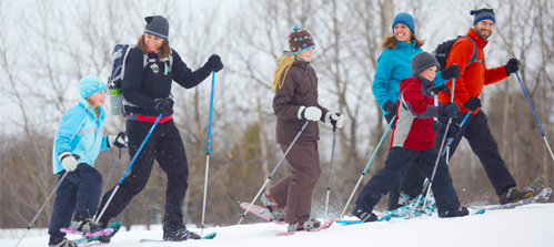 Family group snowshoeing across an open field