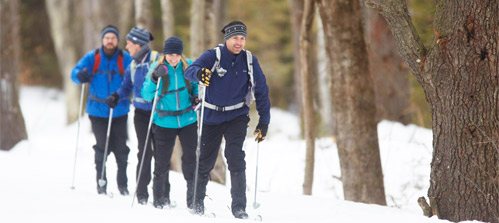 L.L.Bean Outdoor Discovery Schools. Glide through winter on cross-country skis. A group of cross-country skiiers learn the skills to easily glide in groomed tracks from an L.L.Bean instructor.